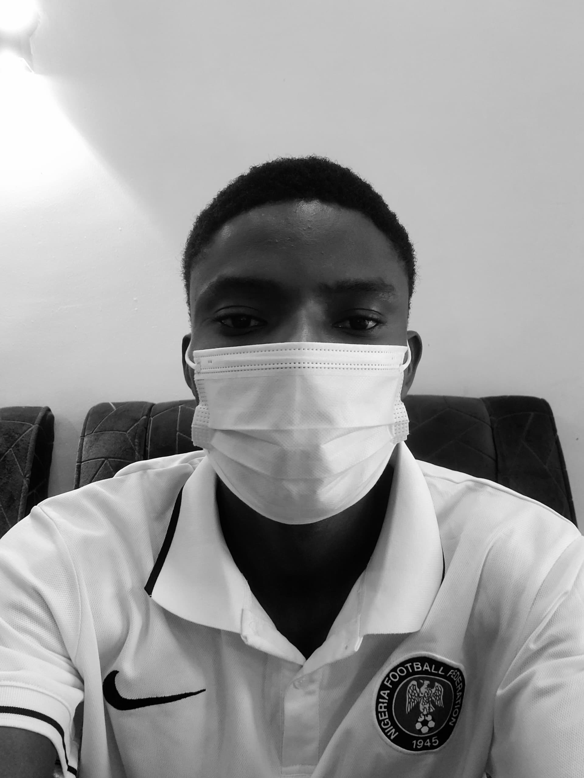 Portrait of a man with brown hair and glasses on a flat gray background.